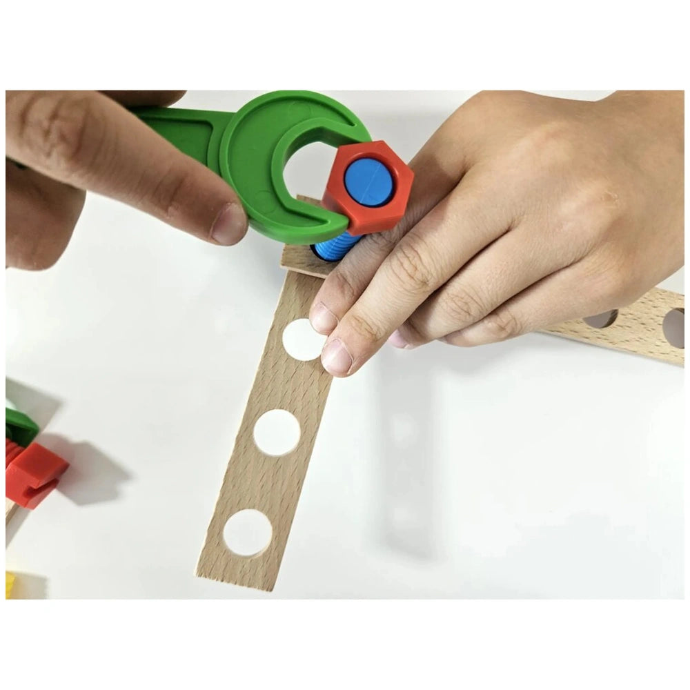 Child assembling wooden pieces with green tool and colorful connector from Alexander Constructor Set.