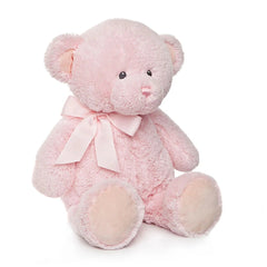 Soft pink teddy bear with a bow, sitting upright, features plush texture and gentle expression.