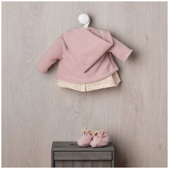 ASI Dolls - María Doll Outfit features a pink cardigan with hood and matching baby shoes on a wooden surface.