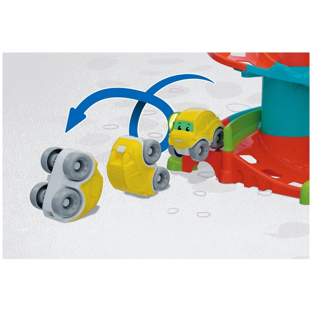 Yellow toy car positioned on a white and gray ball, set against a light-colored background, designed for children's play.