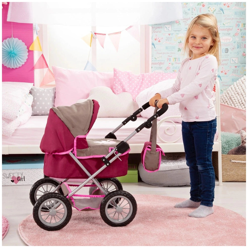 BAYER DESIGN Dolls Pram in trendy red and gray with pink bedding and a young girl playing on a pink rug.
