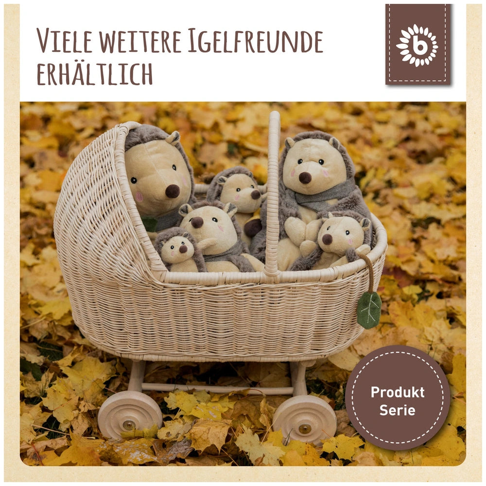 A woven basket filled with various plush hedgehogs, featuring soft textures and friendly facial expressions, surrounded by autumn leaves.