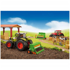 Toy farming scene with green Bruder Amazone Sowing Machine attached to a tractor, alongside figures and farm structures.