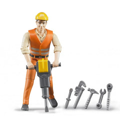 Bruder construction worker wearing an orange vest and yellow helmet holds a jackhammer, with various tools beside him.