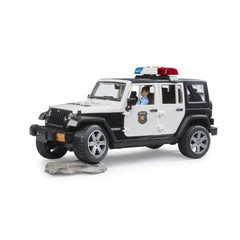 Black and white police Jeep toy with working lights, detailed interior, and a policeman figure inside on a rocky surface.