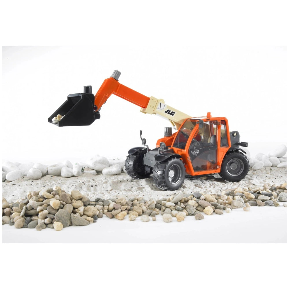 Orange Bruder JLG 2505 Telehandler toy with telescopic arm extended, lifting pebbles on a sandy and rocky surface.