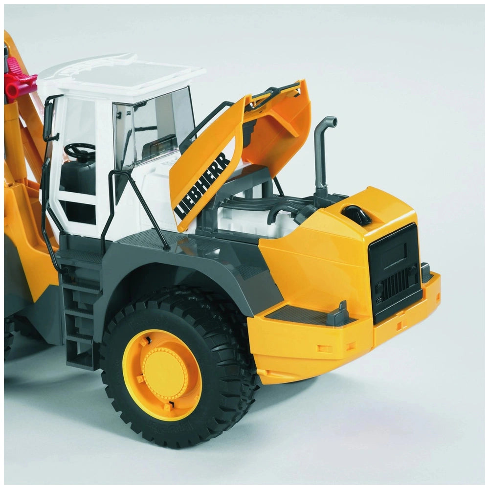 Yellow and gray Bruder Liebherr L574 toy loader with tilting shovel and articulated design on a light background.