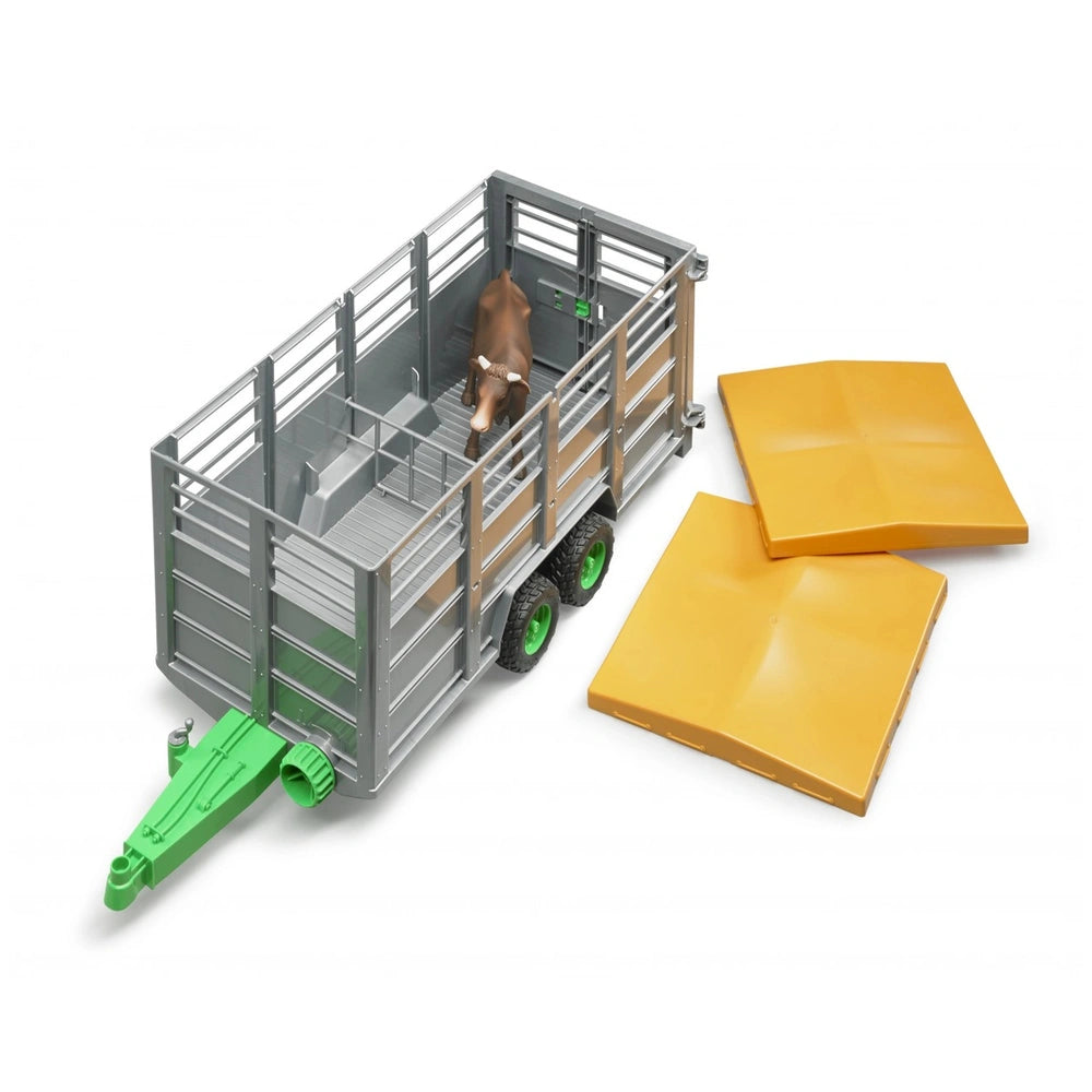 Toy livestock trailer with green hitch, gray sides, and cow inside, accompanied by two yellow ramps on white background.