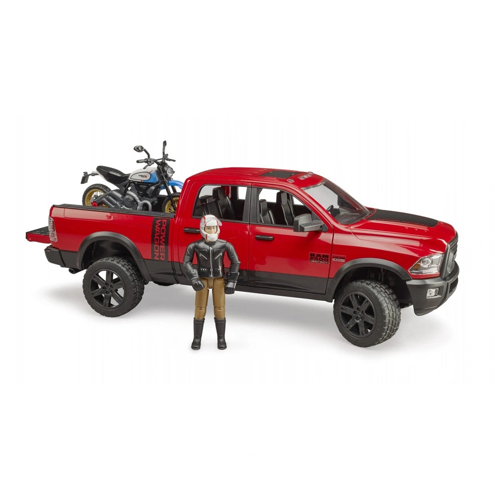 Red Bruder RAM 2500 Power Wagon toy with Ducati Desert Sled in the back and a figure in biker gear standing nearby.