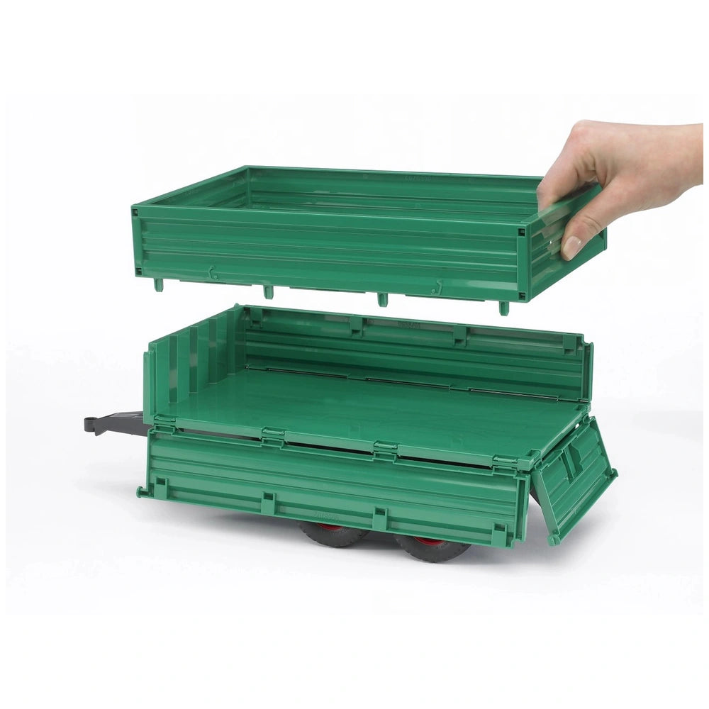 Green Bruder tandemaxle trailer with removable top section being lifted by a hand, showcasing three side gates.