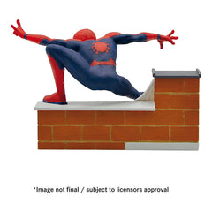 Bullyland Avengers Spider-Man action figure, blue and red, on a white platform against an orange brick wall.