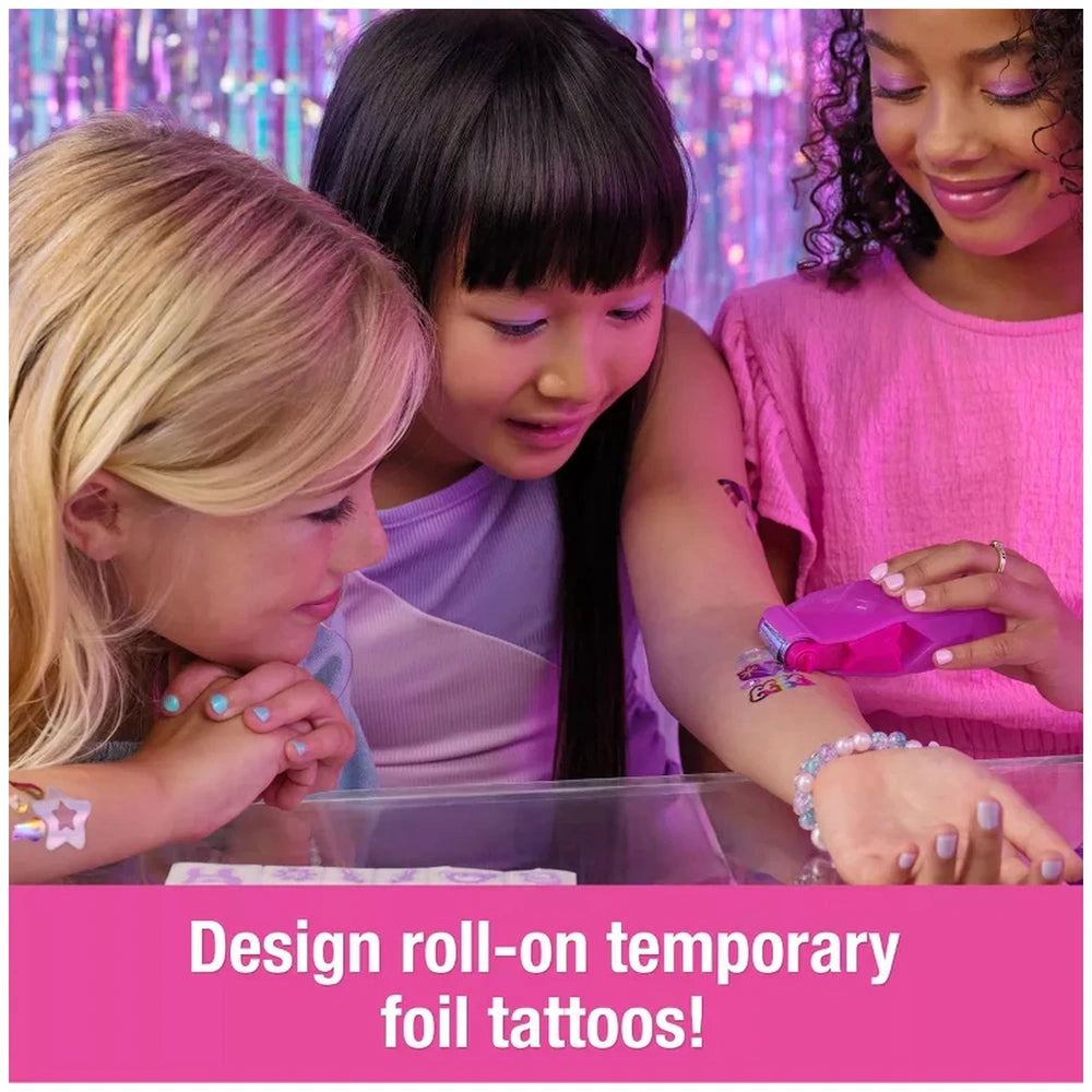 Cool Maker Shimmer Me Body Art Set Makeup displayed with girls admiring temporary tattoos on a smartphone in a festive settin
