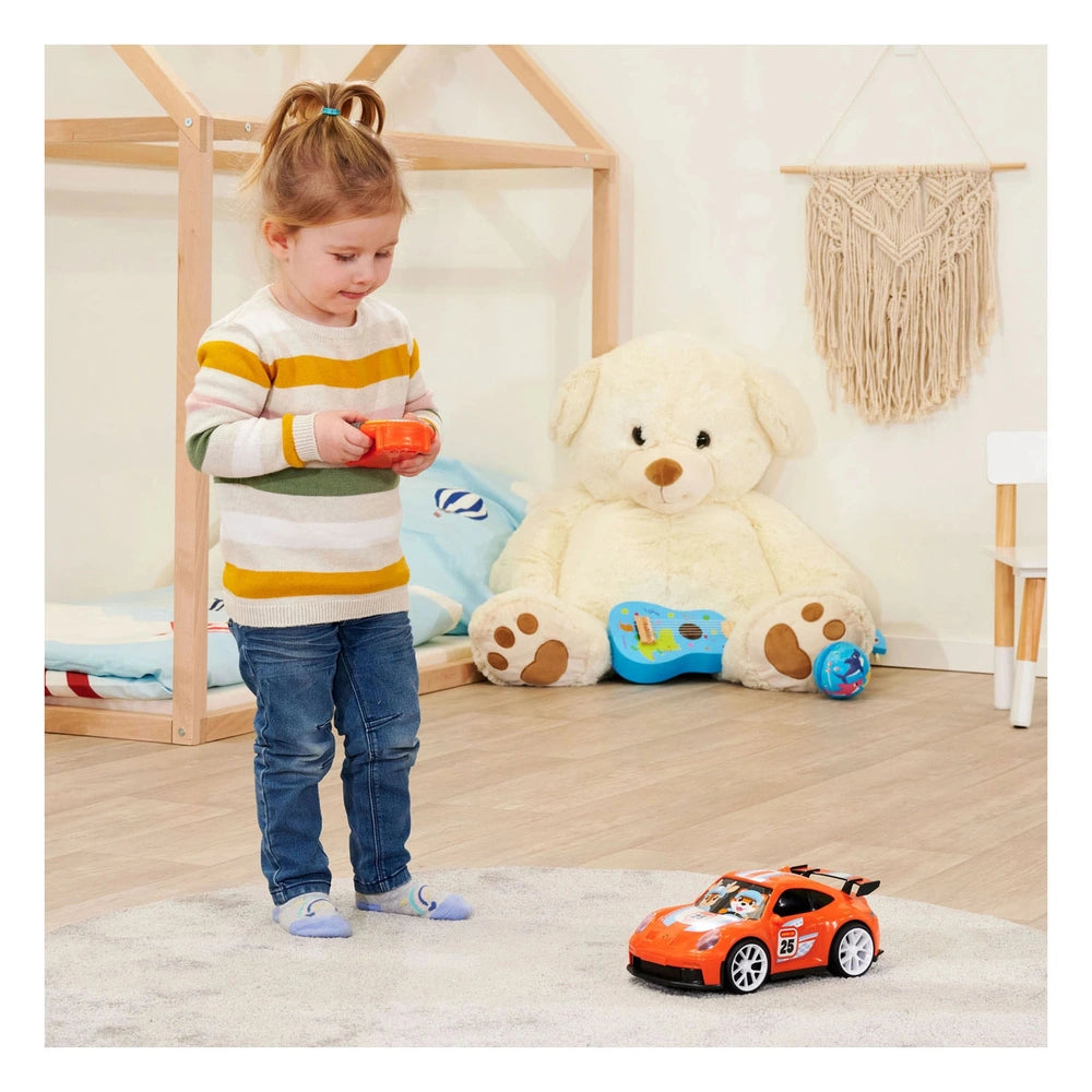 Dickie Abc remote controlled Icc Porsche 911 GT3 play vehicle on wooden flooring with various stuffed animals nearby.