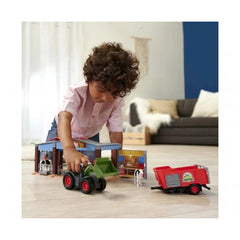 Dickie Farm Station tractor toy playset with green and black cab, red wheels, and figures on light floor in a living room.