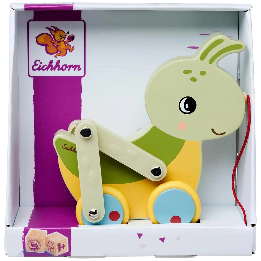 Colorful pulling grasshopper toy with a green body, yellow head, and blue wheels inside an open purple and white box.