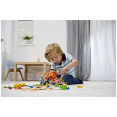 Eichhorn Constructor 4 in 1 construction set is being played with by a young boy on a light-colored carpet in a cozy room.