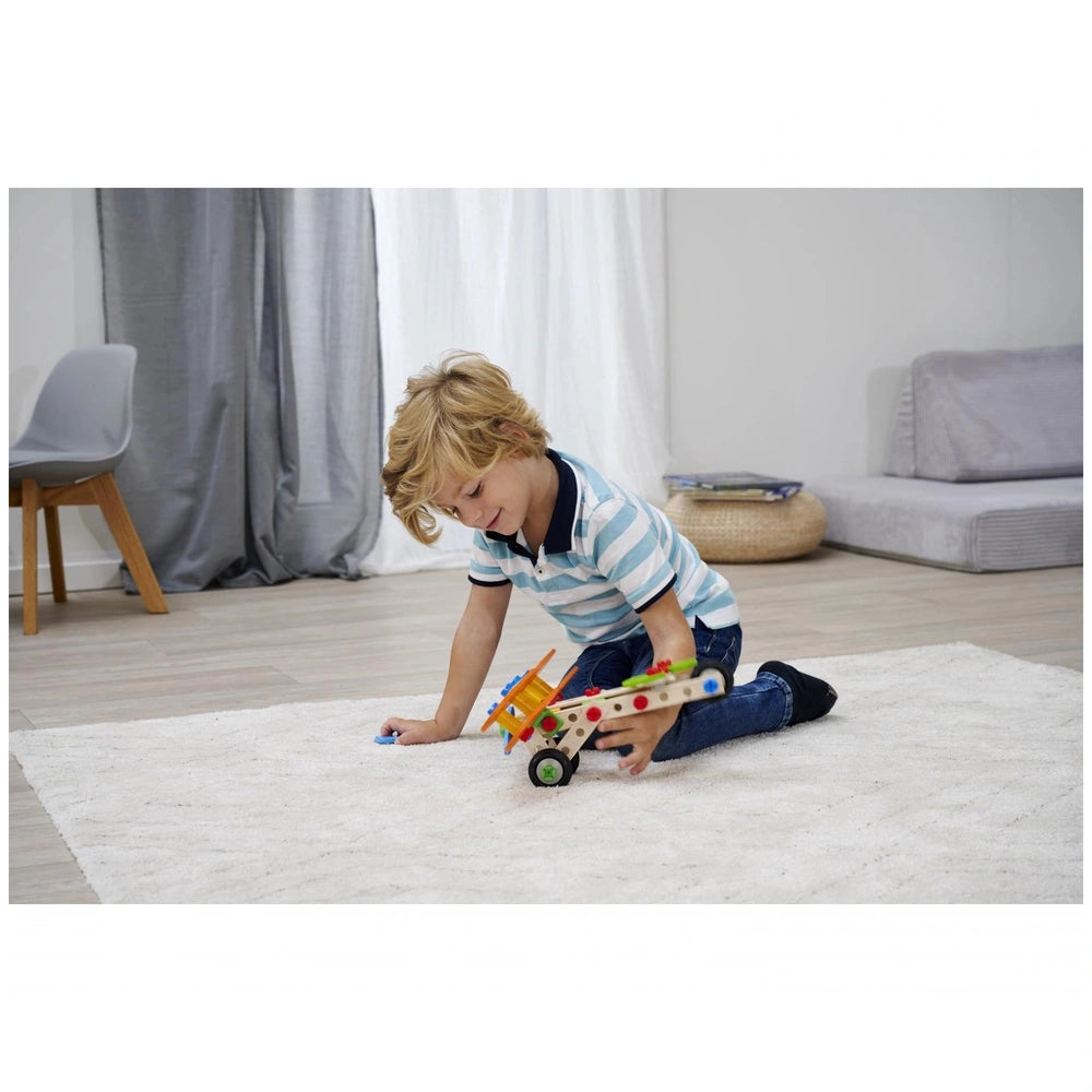 Eichhorn Constructor 4 in 1 construction set is being played with by a young boy on a white shag rug in a cozy indoor setting