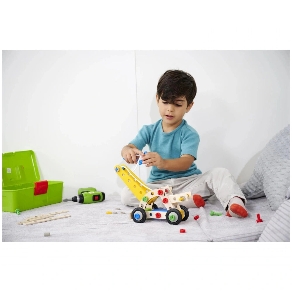 Eichhorn Constructor 4in1 construction set with a child in a blue shirt, engaging with various toy tools on a white surface.