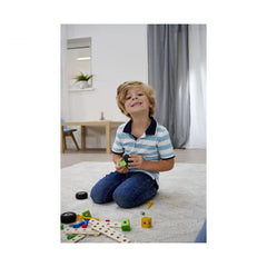 Eichhorn Constructor Accessories set displayed as a child plays happily with colorful toys on a light carpeted floor.