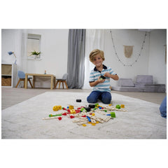 Eichhorn Constructor Accessories construction set toys are spread on a shaggy carpet, with a smiling child engaged in play.