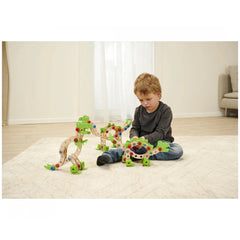 Eichhorn Constructor Dinosaur construction set with green and red pieces is being played with by a child on a white carpet.