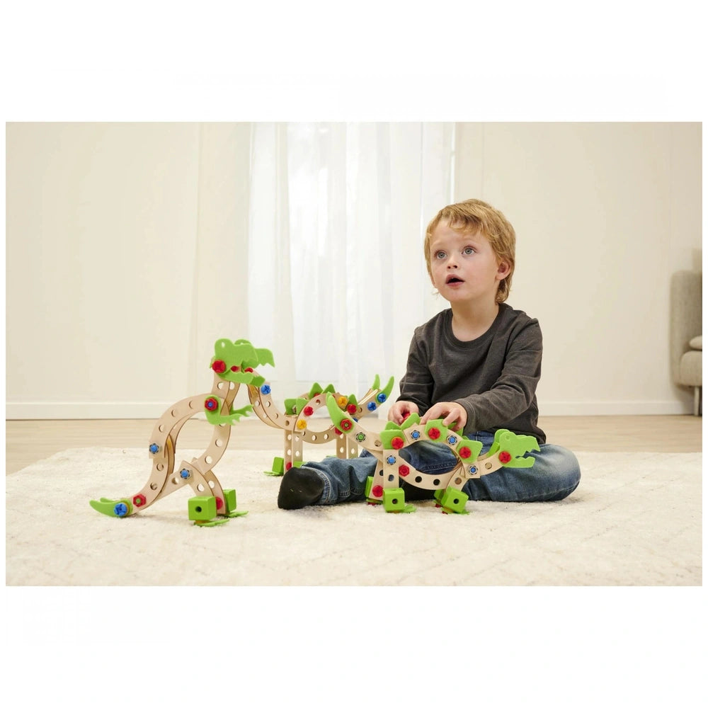 Eichhorn Constructor Dinosaur construction set with colorful parts is being played with by an excited child on a white carpet