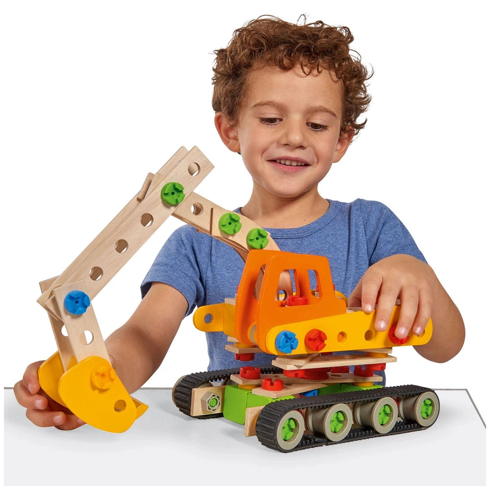 Eichhorn wooden construction toy held by a smiling child in a blue t-shirt, featuring orange, yellow, and green components.