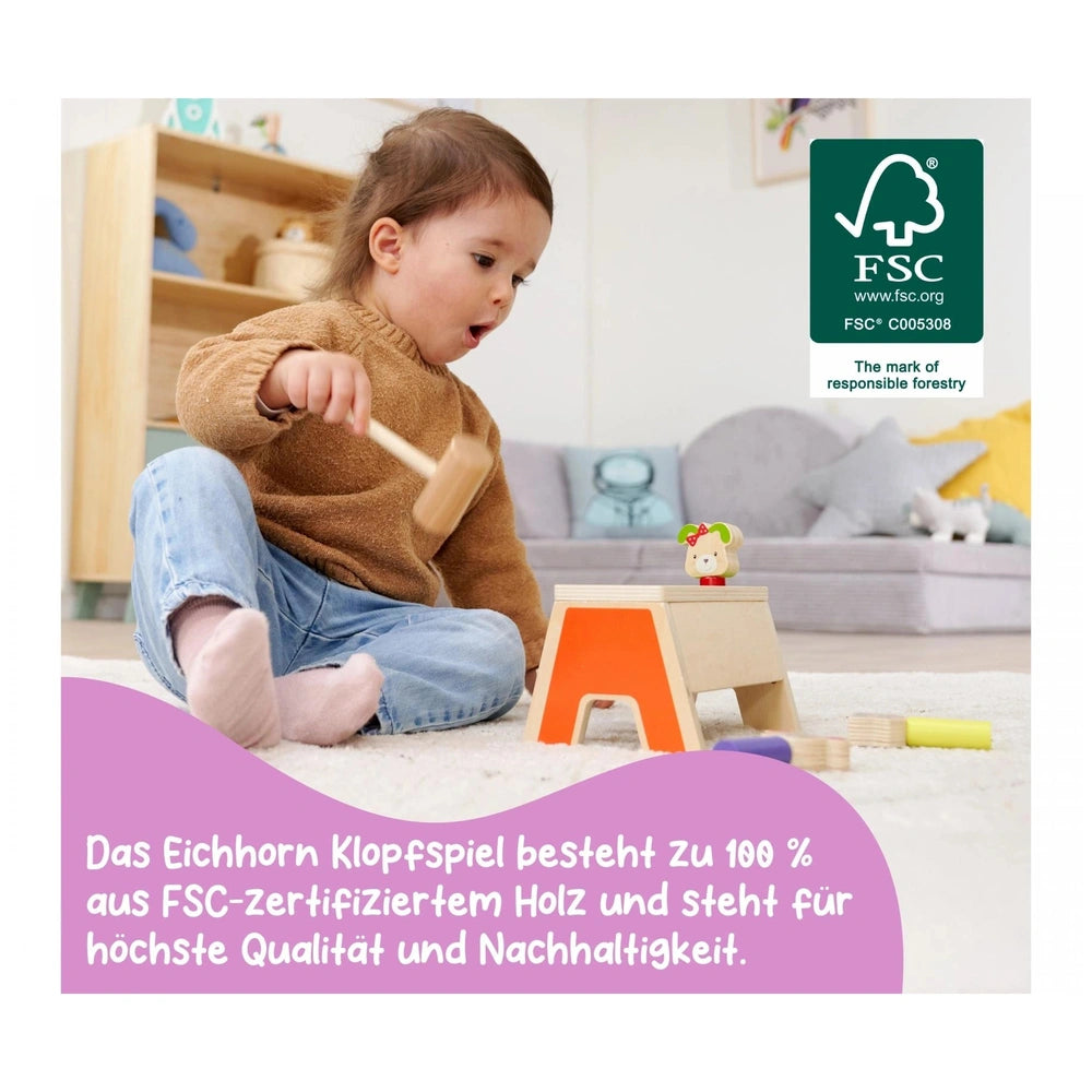 Eichhorn Knocking Game Pop Up with a child playing on a carpet, surrounded by alphabet blocks and a cozy home setting.