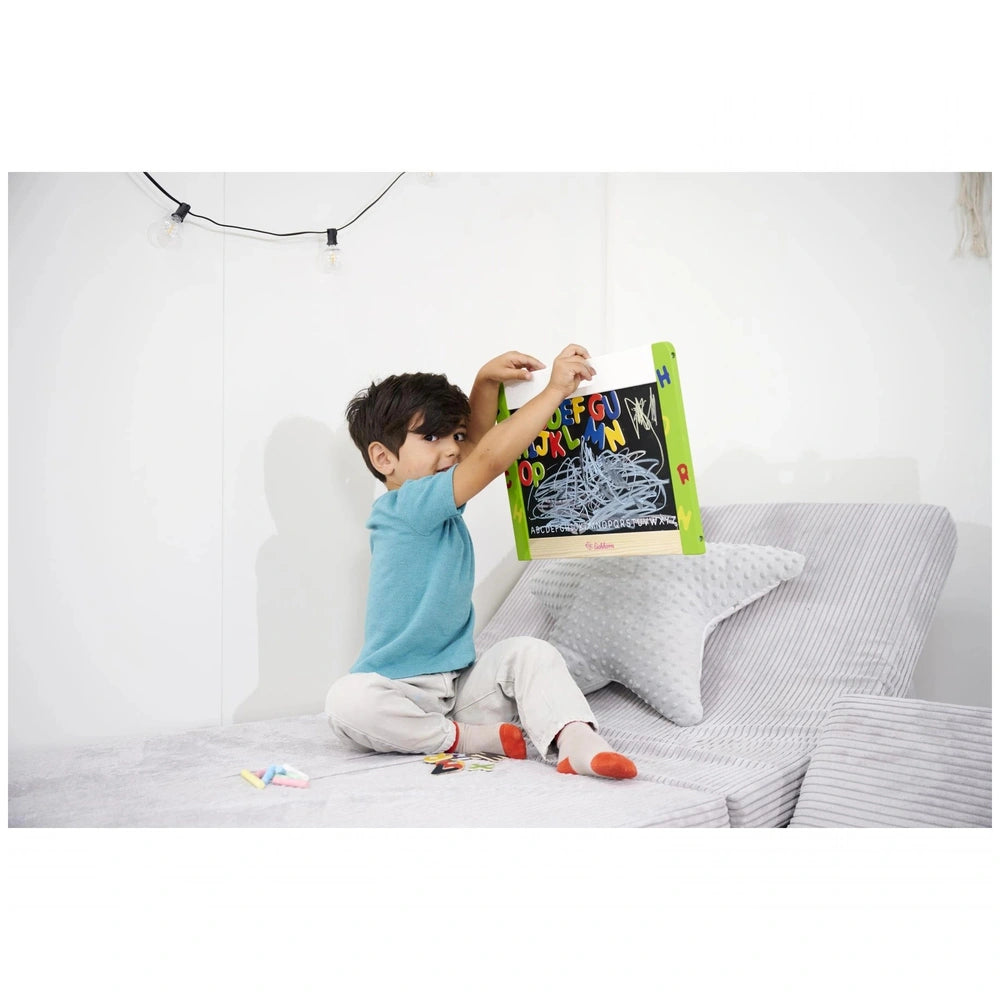 Eichhorn Magnetic and Chalkboard set featured with a focused child exploring a colorful book in a minimalist room.