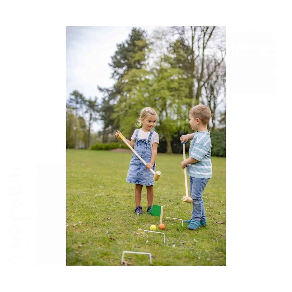 Eichhorn Outdoor Croquet Set showcases children playing on grass with colorful rackets and an obstacle course in a sunny park