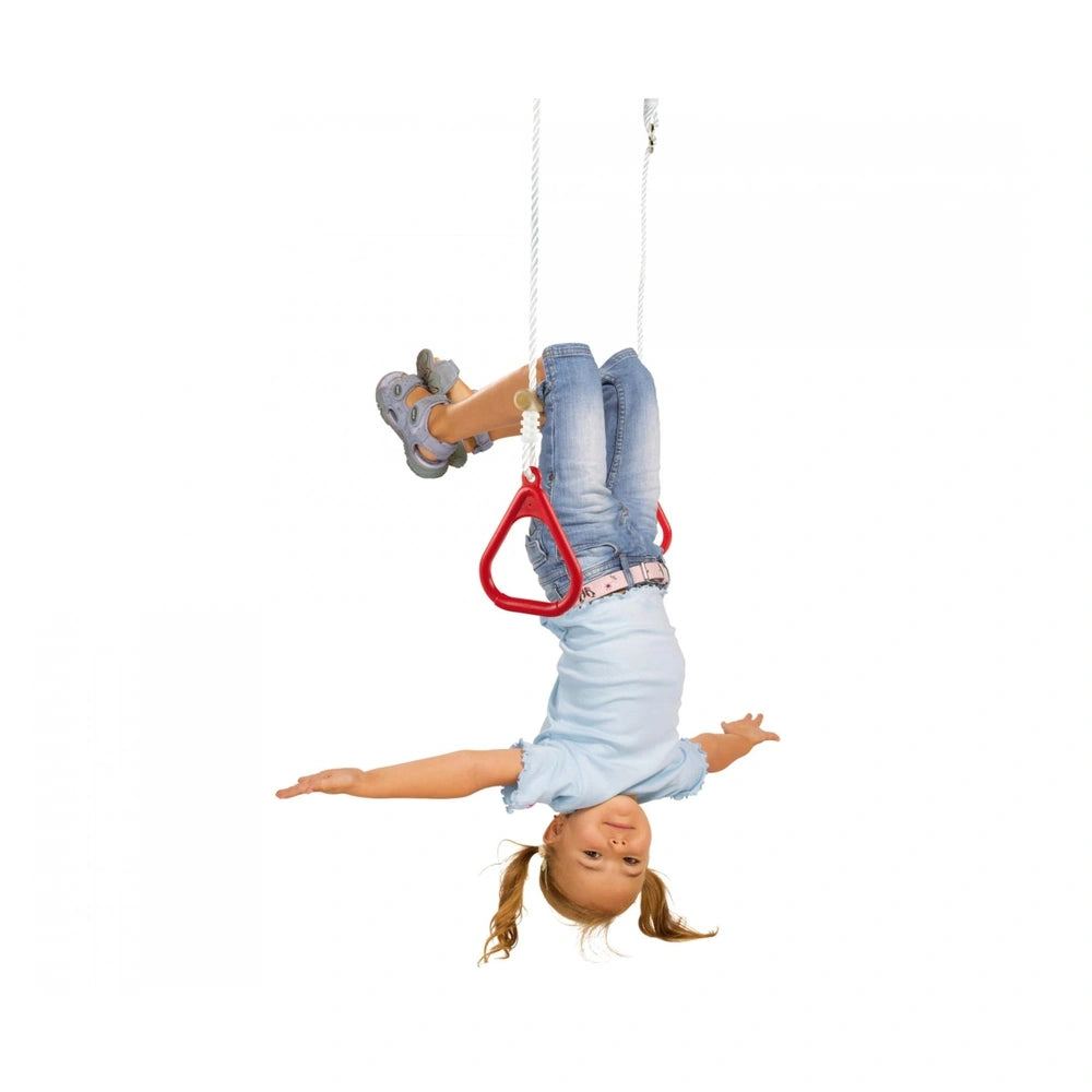 Eichhorn Outdoor Gymnastics Rings featuring a joyful child in a blue outfit playfully hanging from a red swing.