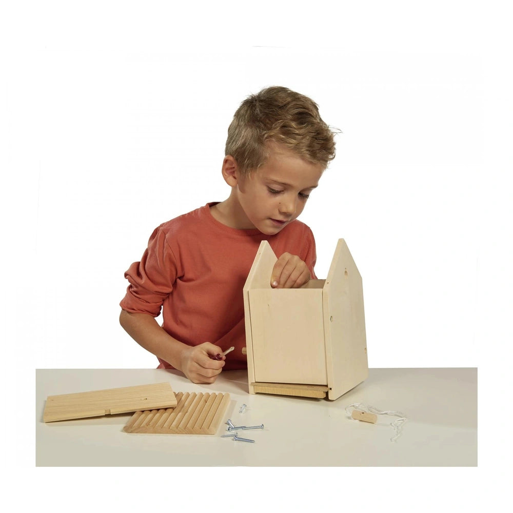 Eichhorn Outdoor Make your own Birdhouse kit with a boy assembling wooden blocks at a table.