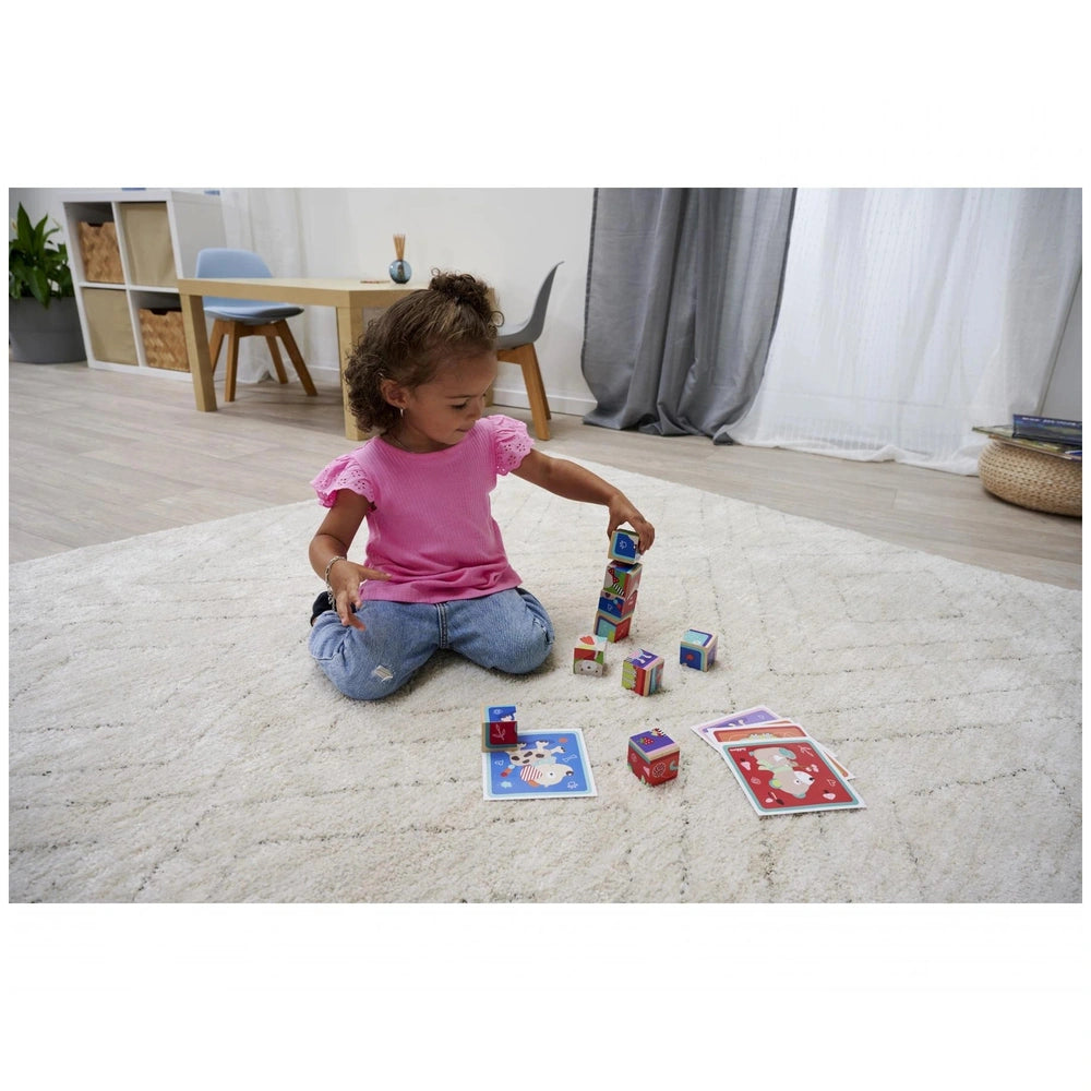Eichhorn Picture Cube Friends displaying a child playing on a rug with colorful toys in a cozy home setting.