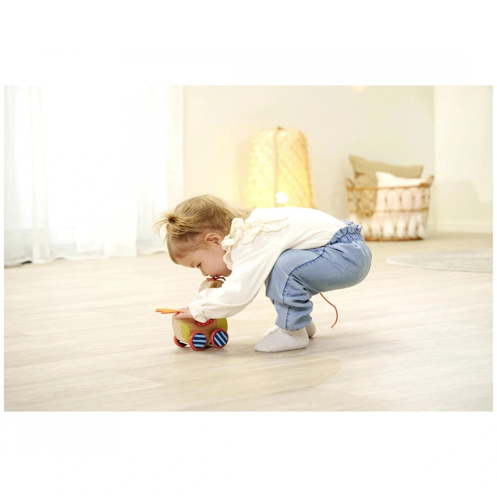 Eichhorn Pull-along Animal Duck toy being enjoyed by a toddler on a wooden floor in a cozy, well-lit room.