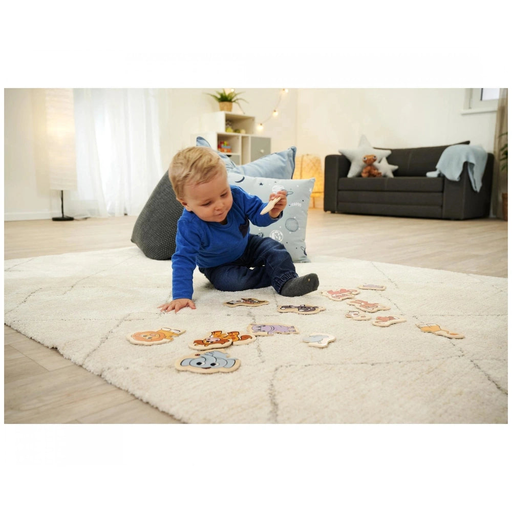 Eichhorn Wooden Animal Puzzle with 16 colorful pieces, child engaged on rug in a cozy living room.