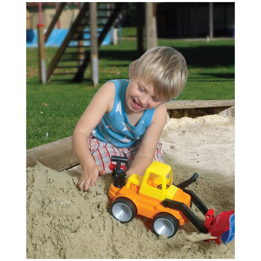 Gowi Bulldozer with rear shovel being played with by a blonde child in a blue star tank top on a sandy playground.