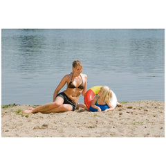 Happy People Aqua Splash Swim Ring in red, white, and blue with child at beach, surrounded by sand, water, and grass.
