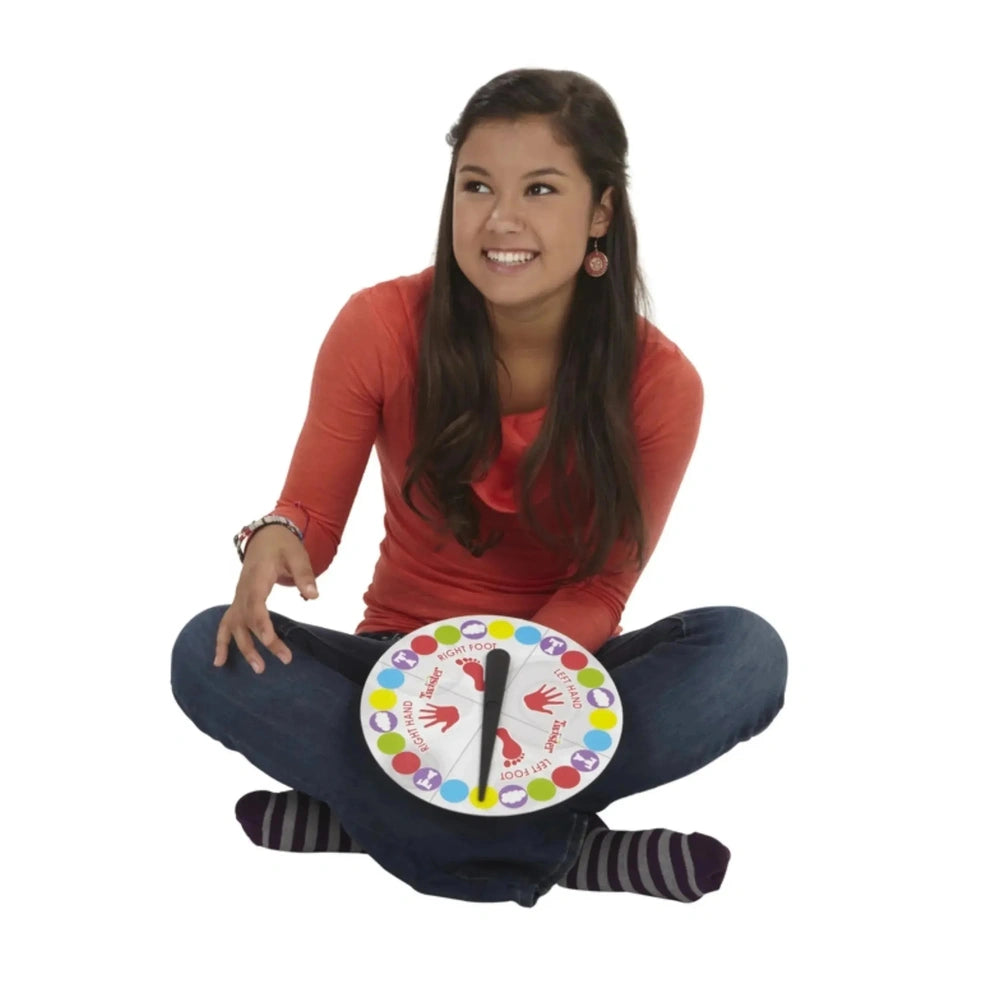 HASBRO Twister Italian Edition board game in a lifestyle scene with a woman in a red top, holding a colorful plate with icons