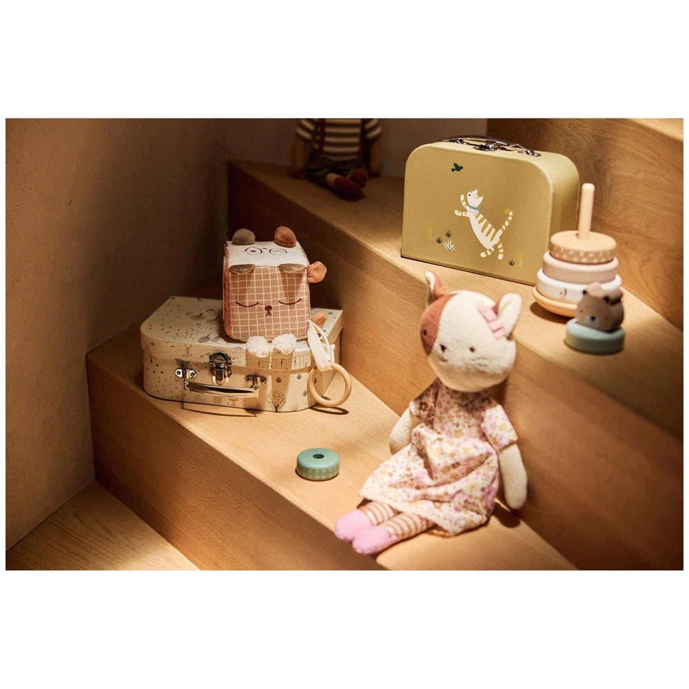 Jollein Activity Cube features a pink stuffed animal on a brown wooden surface with tan and white striped ribbons and a gloss