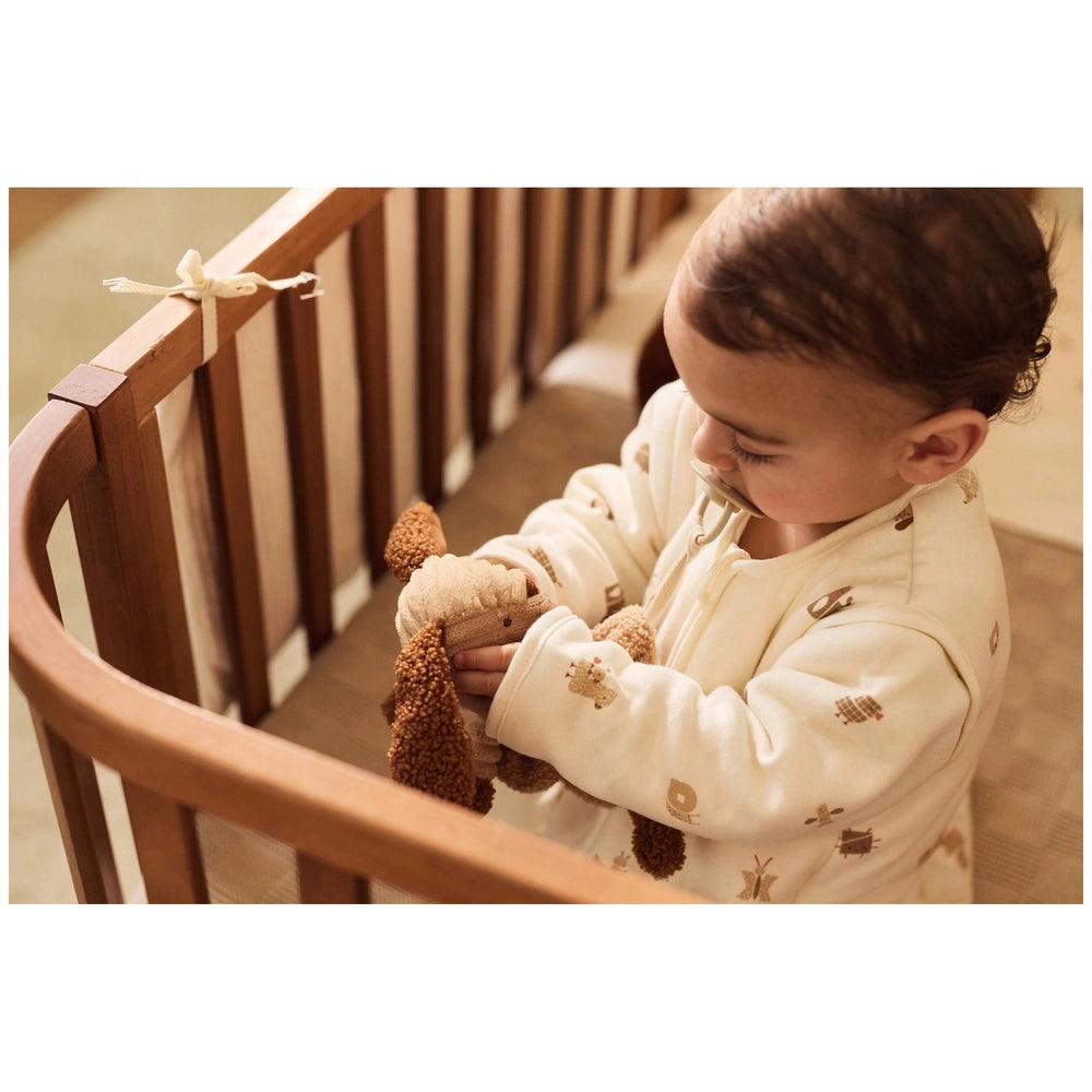 Jollein pacifier cloth animal friends featured with a child in a white jacket holding a fuzzy brown stuffed animal.