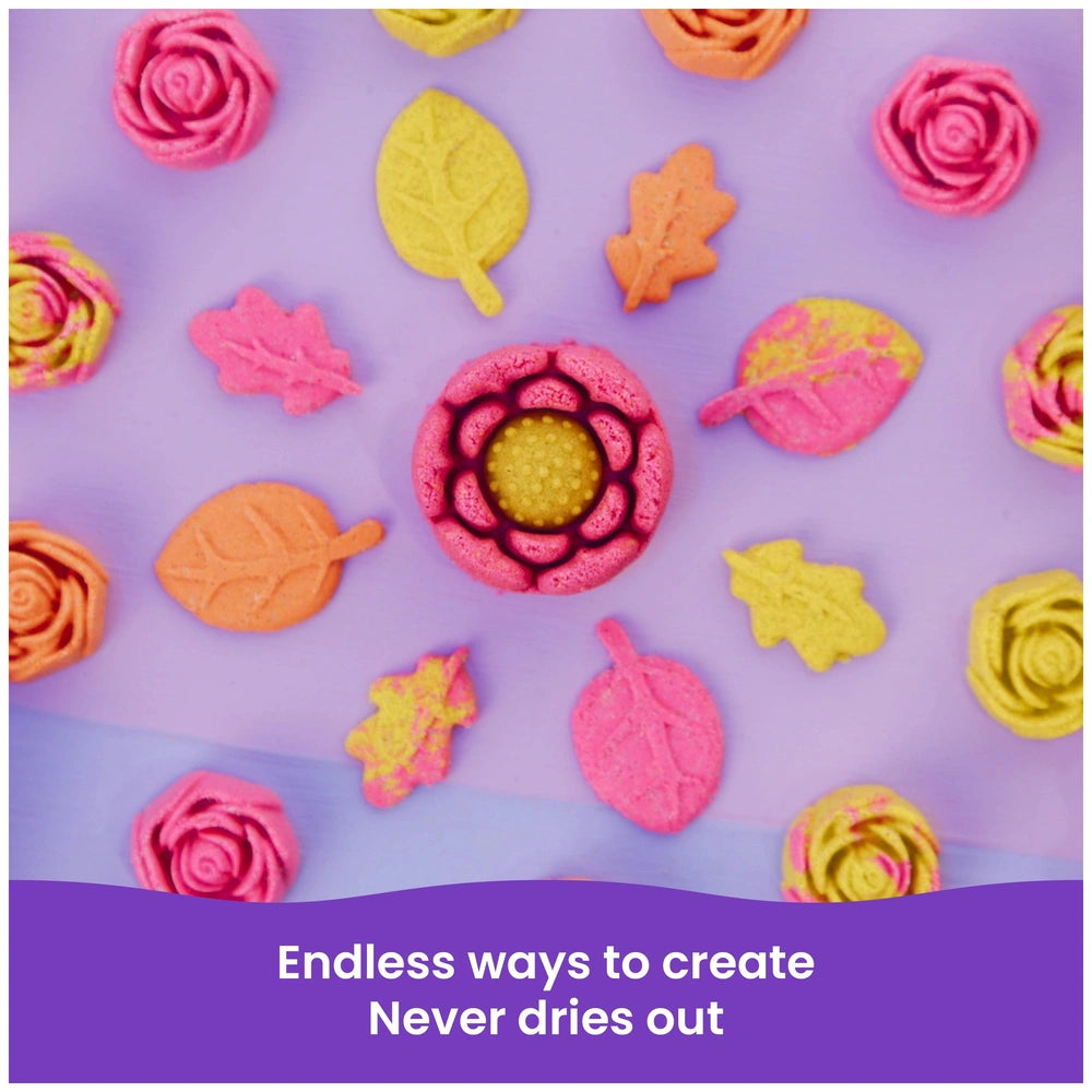 Kinetic Sand Squish Blossom features colorful, soft flower and leaf shapes arranged in a circular pattern on a purple backgro