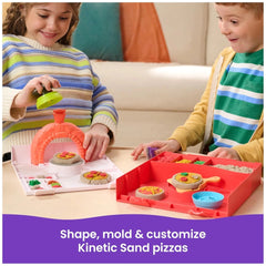 Kinetic Sand Squish Pizza set with children playing, featuring a red pizza oven and colorful toppings on a white table.