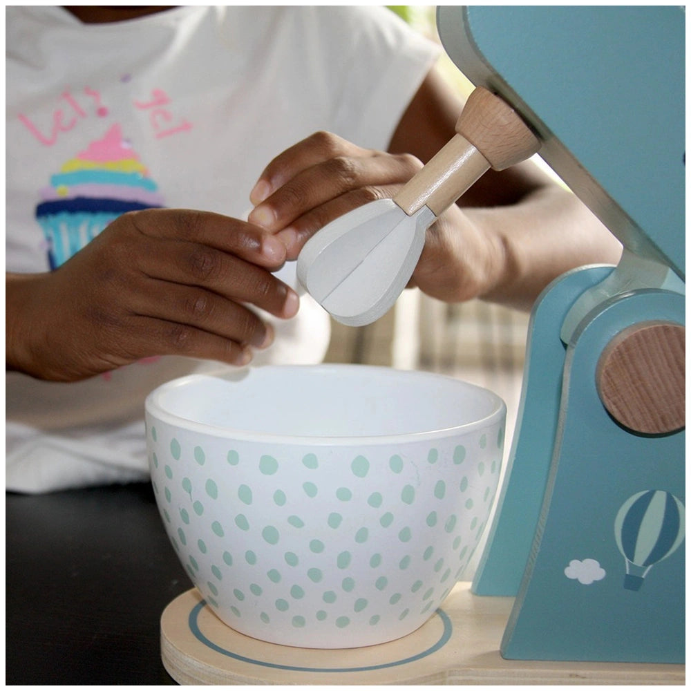 White ceramic bowl with green circle pattern and brown wooden spoon, designed for pretend play food processing.