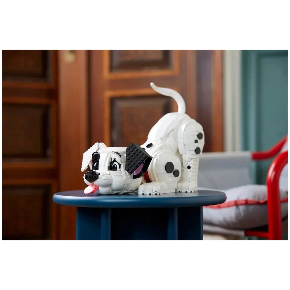 LEGO 101 Dalmatians puppy toy in white with black details, placed on a blue table in an indoor setting.