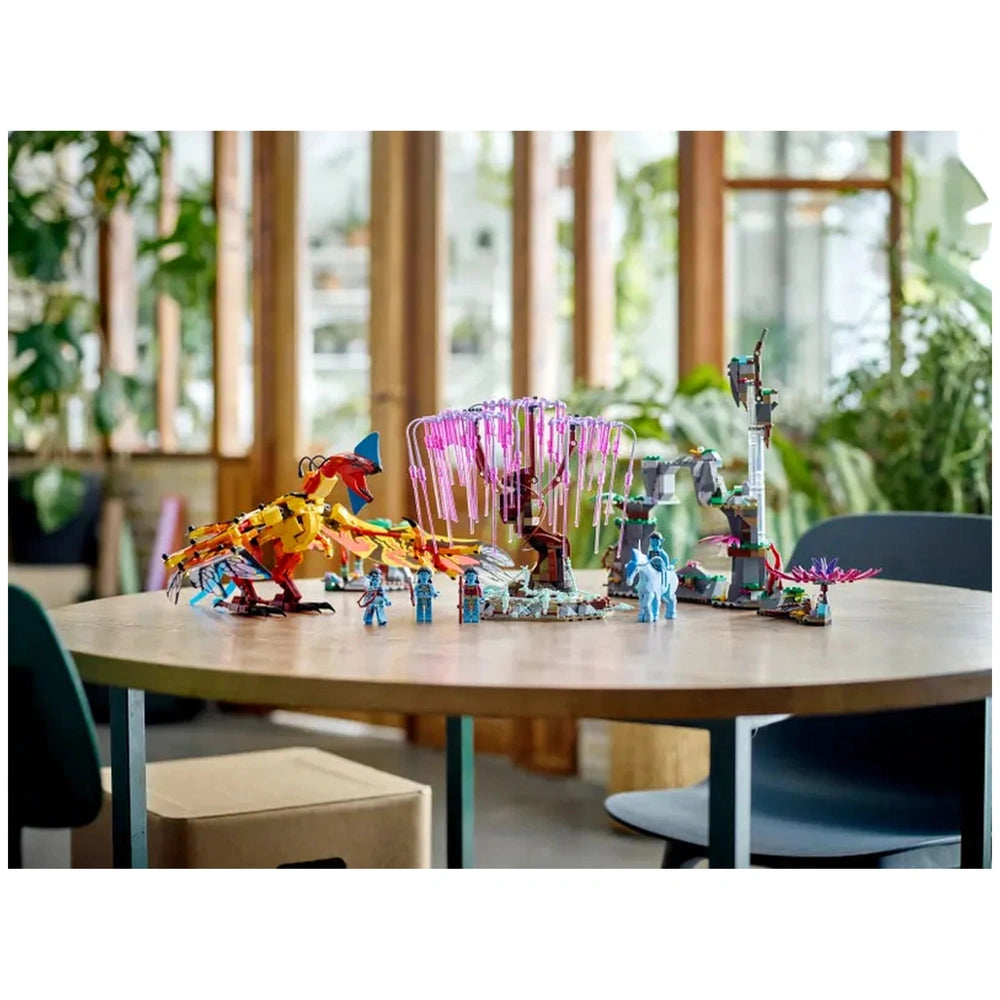 Colorful LEGO® Avatar set featuring a detailed Toruk figure, Tree of Souls with pink tendrils, and four minifigures on a wooden table.