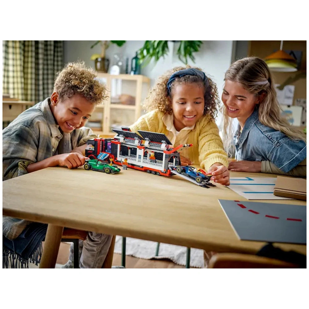 Three children and an adult gather around a wooden table, engaging with the LEGO® City F1® Truck set. The truck features a detachable trailer, and the children are playfully positioning the colorful RB20 and AMR24 F1® cars. Bright, cheerful expressions highlight their excitement as they explore this immersive racing-themed playset. A cozy, well-lit room serves as the backdrop.