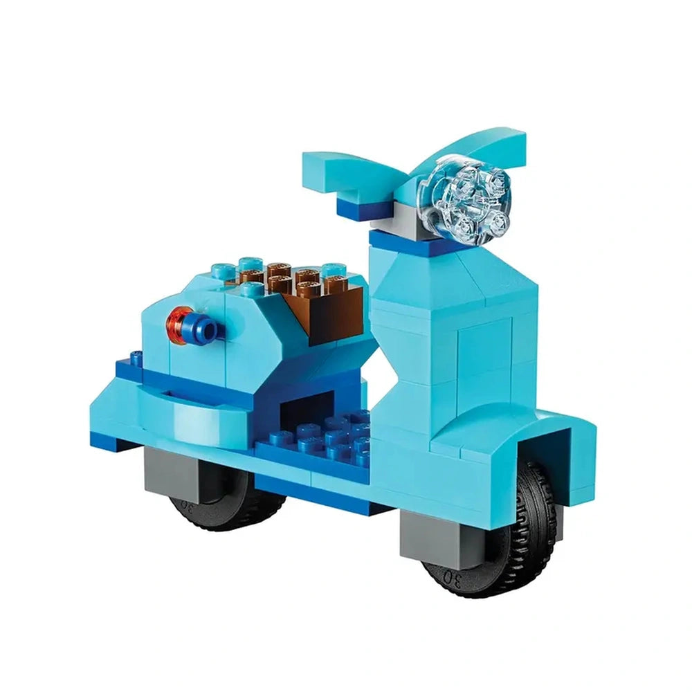 Blue LEGO scooter featuring a stylish design, with a rounded body, clear front light, and black wheels, ready for imaginative play.