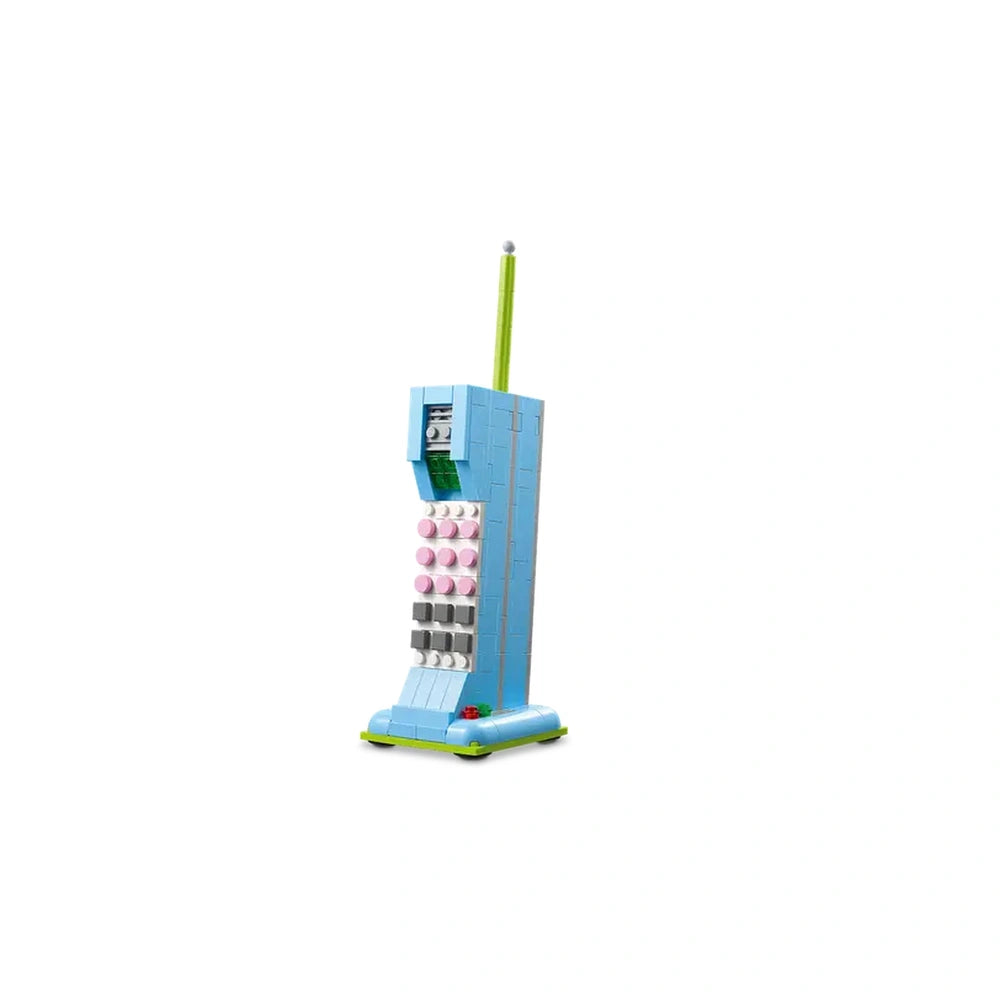 Retro LEGO construction set resembling a vintage telephone, featuring a blue body, pink buttons, and a green antenna, designed for creative play.