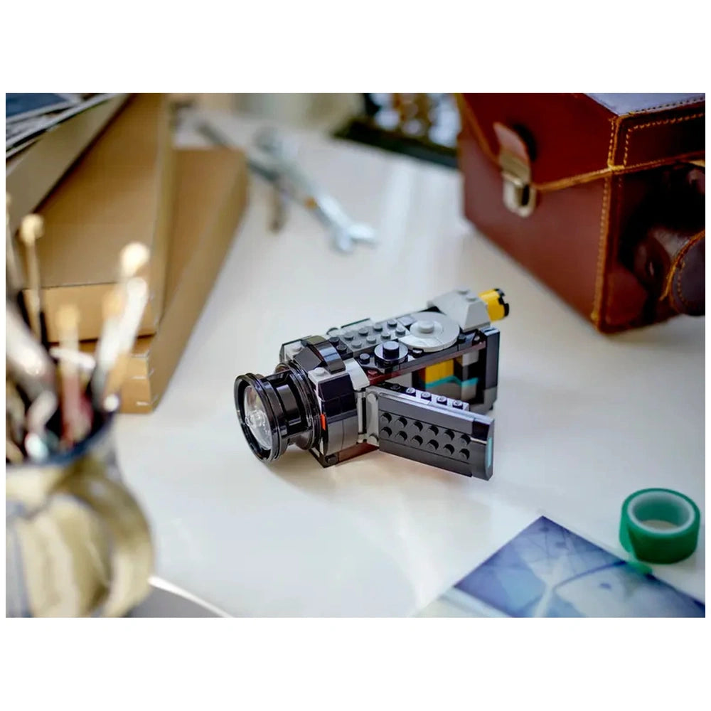 LEGO® Creator Retro Camera set on a tidy desk, showcasing a detailed retro design with a moving lens, functional buttons, and an opening back for film insertion.
