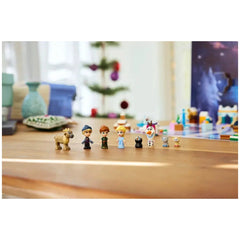 LEGO Disney Frozen Advent Calendar 2025 featuring mini figures of Disney characters: Anna, Elsa, Kristoff, Olaf, and two kittens, with Sven beside them. A decorated Christmas tree is in the background, set on a wooden table.